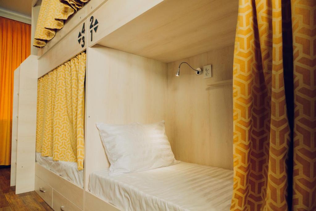 a bed in a tiny house with a window at Evergreen Hostel in Almaty