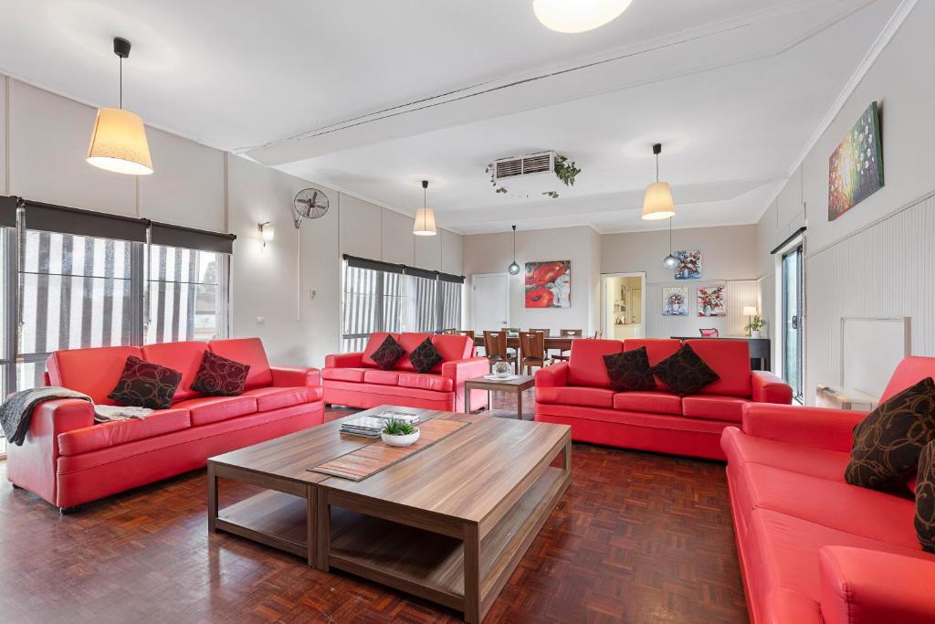 ein Wohnzimmer mit roten Sofas und einem Tisch in der Unterkunft Spacious 4 Bdrms near Murray River, Pet Friendly in Strathmerton