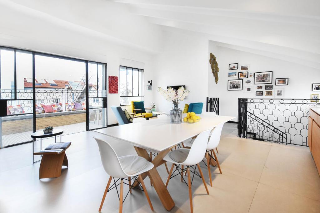 een eetkamer met een witte tafel en stoelen bij Haivy Land by HolyGuest in Tel Aviv