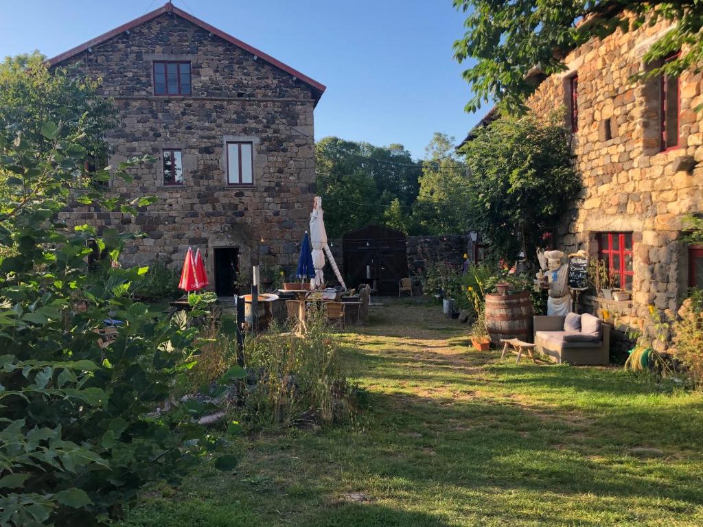 an old stone building with a garden in front of it at Le Marconnès in Saint-Arcons-de-Barges