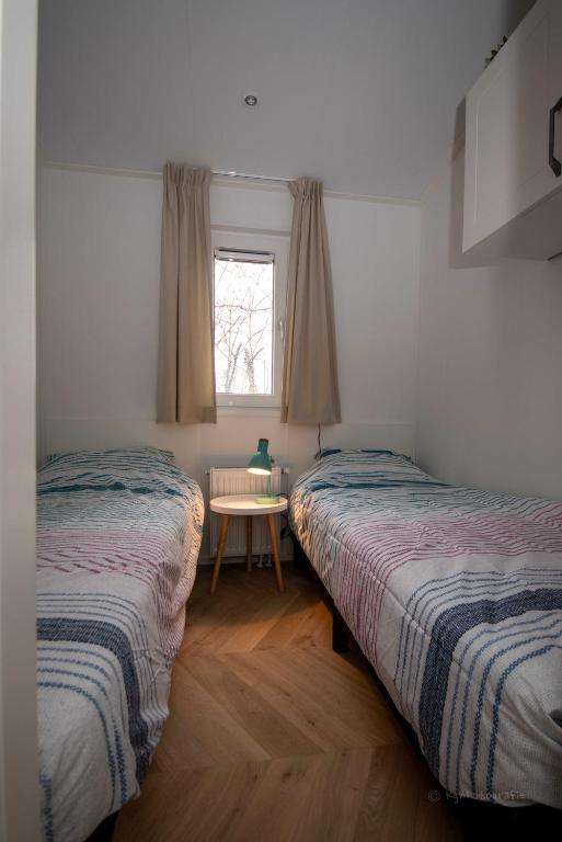 Postel nebo postele na pokoji v ubytování Chalets op Minicamping Dorpszicht