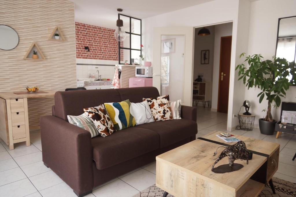 a living room with a brown couch and a coffee table at Le Pompidou T2 pour 2 à 4 pers avec parking privé & balcon Place Ney in Angers