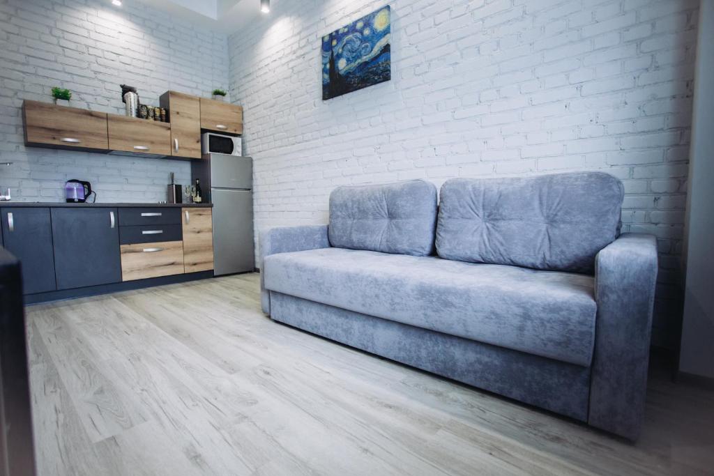 eine blaue Couch in einer Küche mit Ziegelwand in der Unterkunft LOFT de luxe apartments in Winnyzja