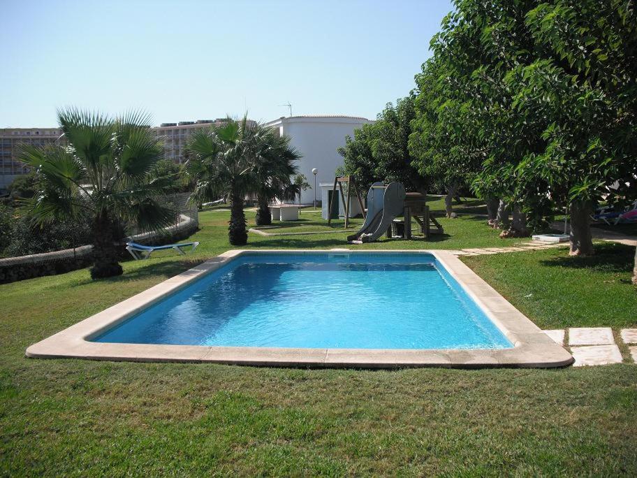 uma pequena piscina num quintal com árvores em Apartamento Calan Forcat en Ciutadella de Menorca em Ciutadella