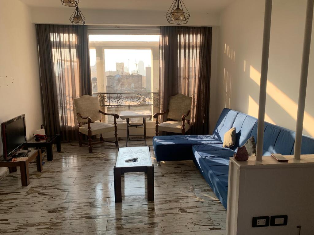 sala de estar con sofá azul y mesa en Beautiful and cozy duplex in the heart of Cairo en El Cairo