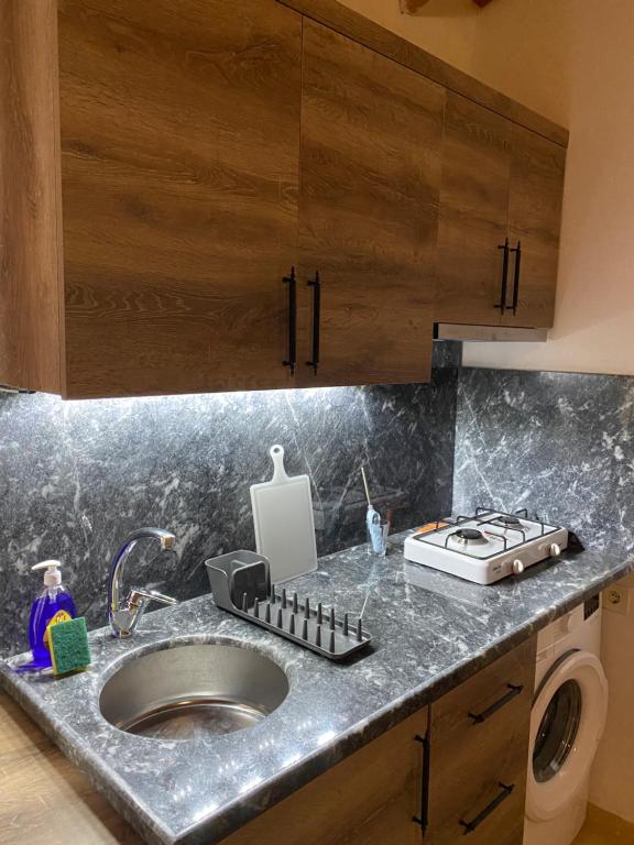 a kitchen counter with a sink and a stove at Safir Pansiyon in Cıralı