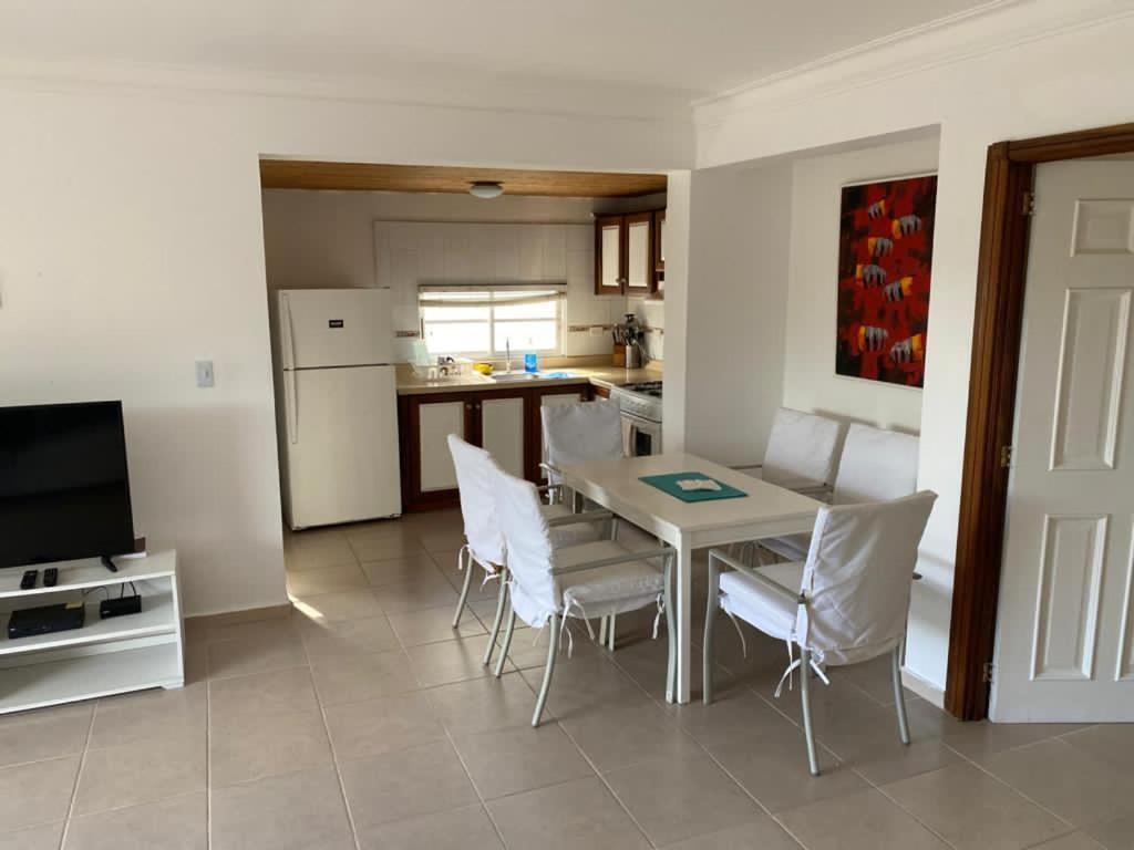 eine Küche und ein Esszimmer mit einem Tisch und Stühlen in der Unterkunft Los Corozos apartment M2, Guavaberry Golf & Country Club in Juan Dolio