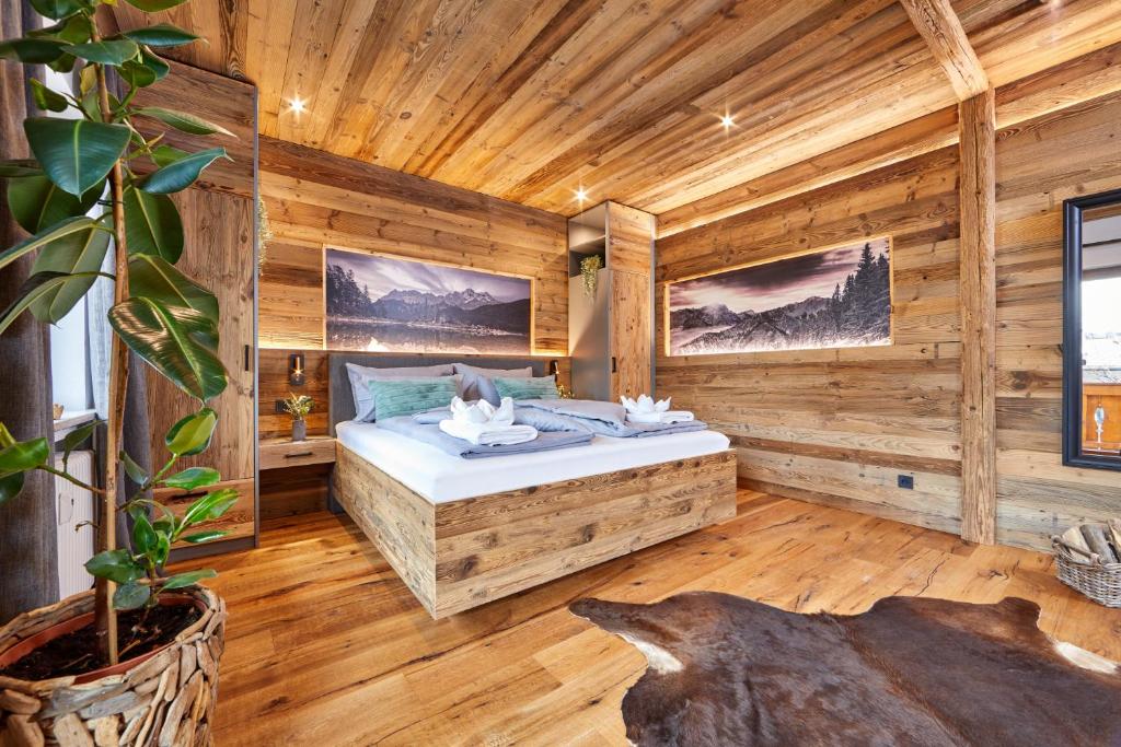 1 dormitorio con 1 cama en una habitación de madera en Alpis Ferienwohnung, en Garmisch-Partenkirchen
