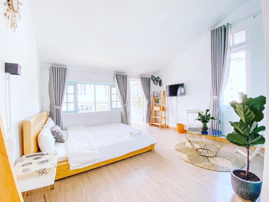 - une chambre blanche avec un lit et un canapé dans l'établissement Together is Home, à Đà Lạt