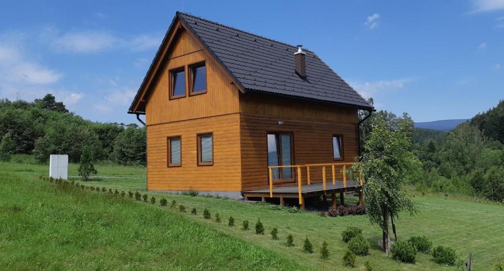 a large wooden house on a green field at Chata Karamelka in Dolní Moravice