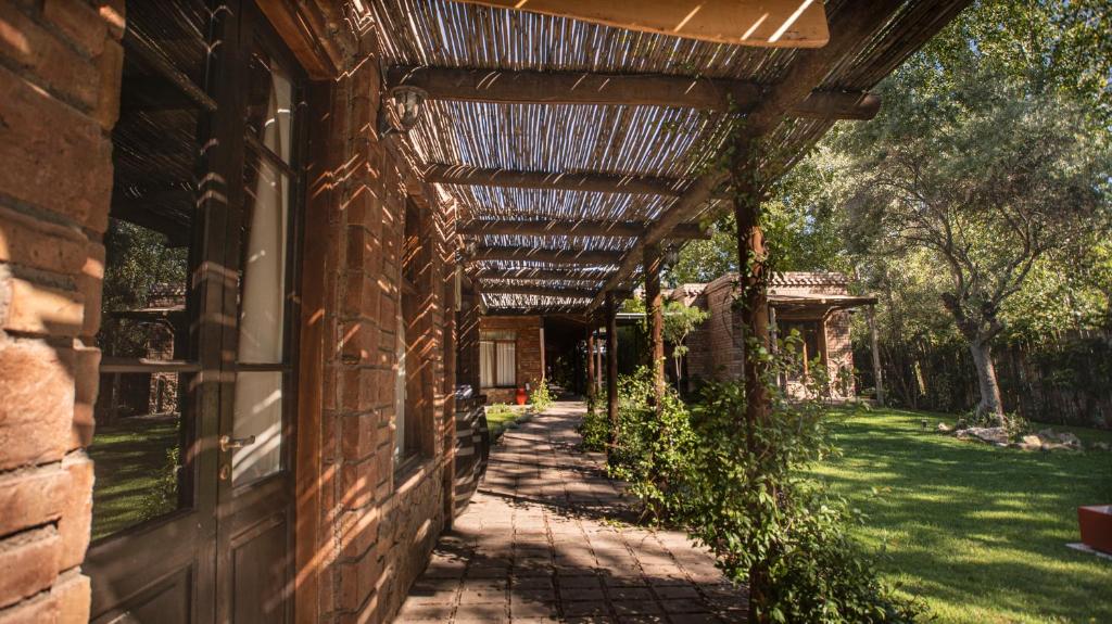 vine covered pathway leading to different rooms at Posada Boutique El Encuentro Chacras de Coria