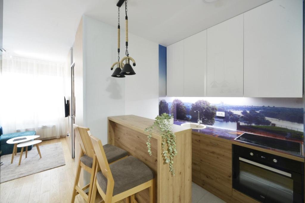 a kitchen with a wooden counter and a dining room at Duki New Belgrade in Belgrade