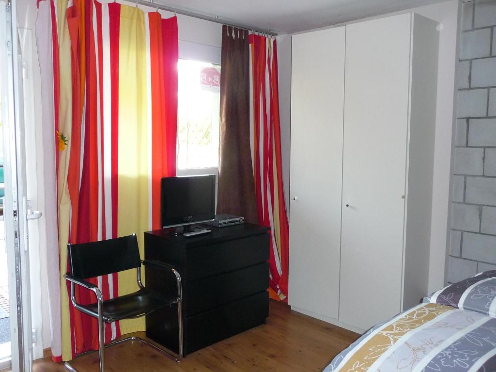 una camera con letto e scrivania con TV di Studios Faoug a Faoug