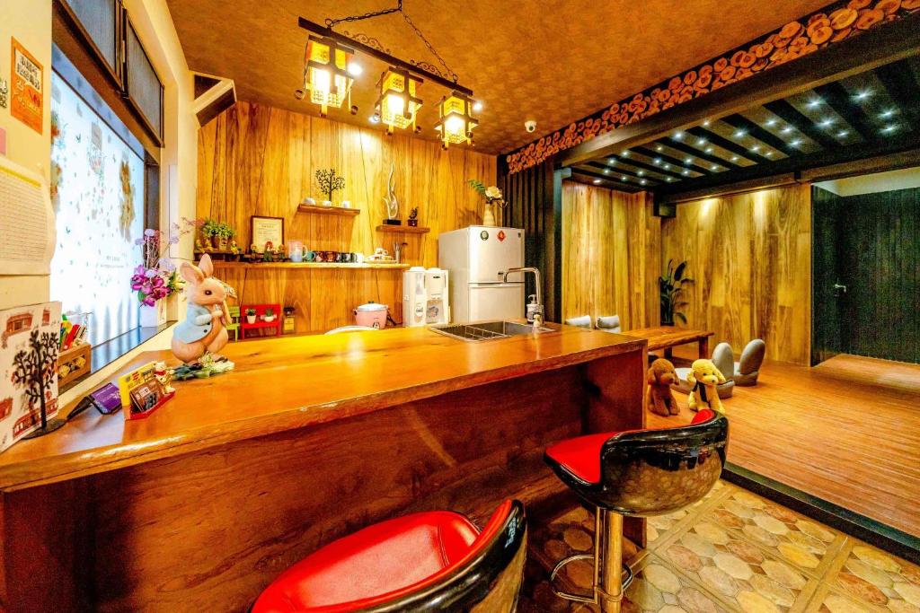 羅東鎮的住宿－貓偷懶民宿，厨房设有酒吧,里面摆放着红色椅子
