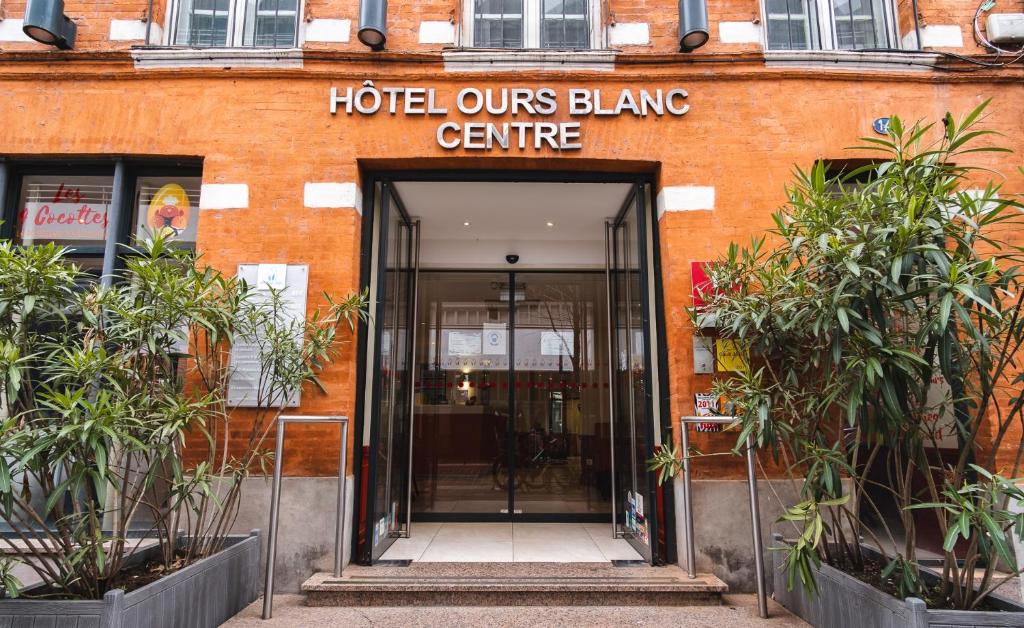 una entrada a un edificio con un hotel nuestro centro de parpadeo en Hotel Ours Blanc - Centre, en Toulouse