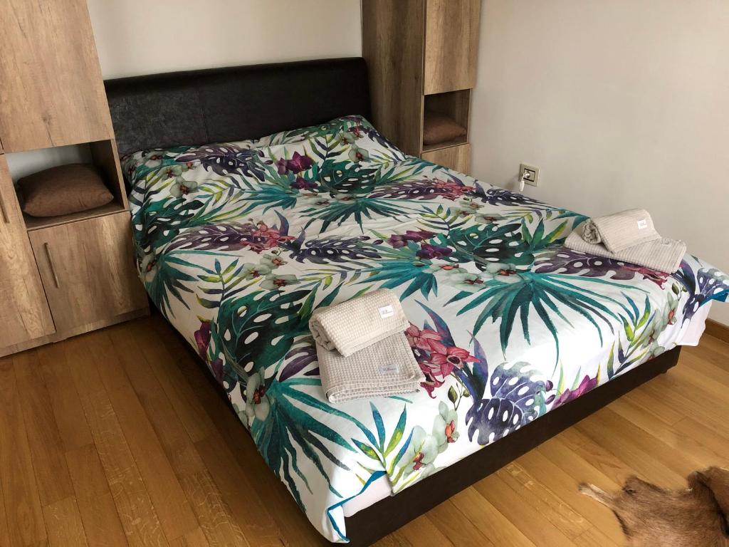 ein Schlafzimmer mit einem Bett mit einer tropischen Tagesdecke in der Unterkunft Apartman LUX STELLA in Zlatibor