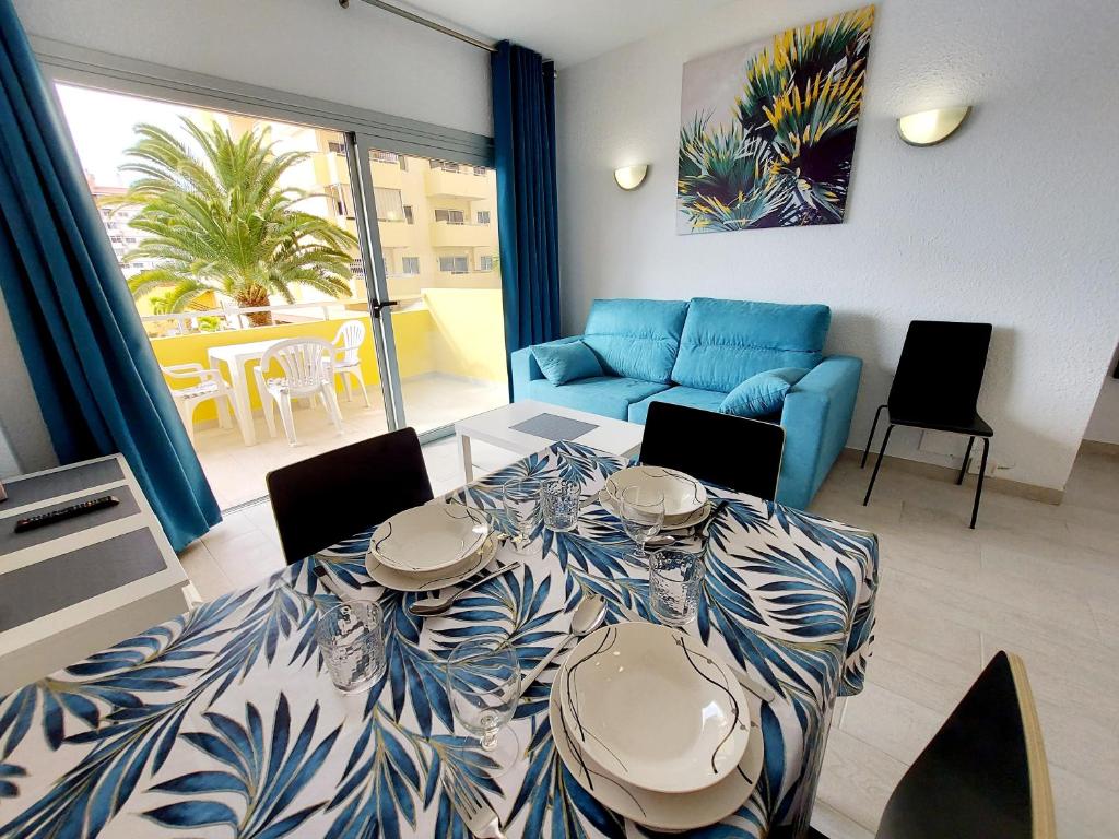 - un salon avec une table et un canapé bleu dans l'établissement Sunny Cozy Nice Apartment LosCristianos WiFi,Pool, à Los Cristianos