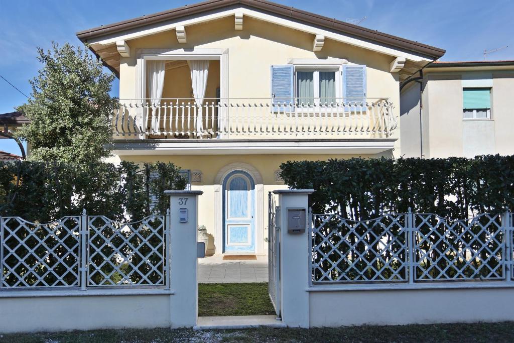 una casa bianca con cancello blu e recinzione di Villa Mony. 100 mt dal mare! a Pietrasanta