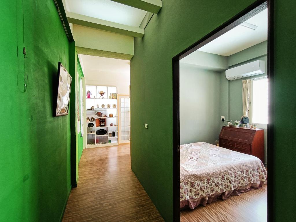 Habitación verde con cama y espejo en 博愛泊旅讀心境, en Hualien City