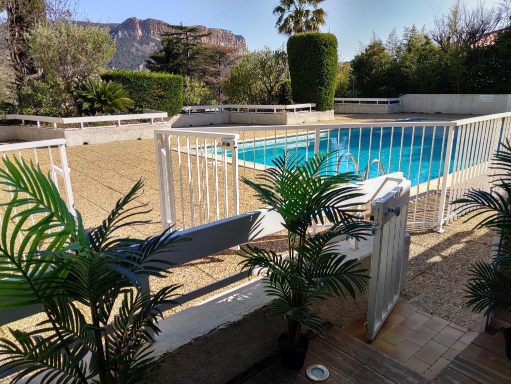 una piscina con una valla blanca y plantas en Le Club, en Cassis