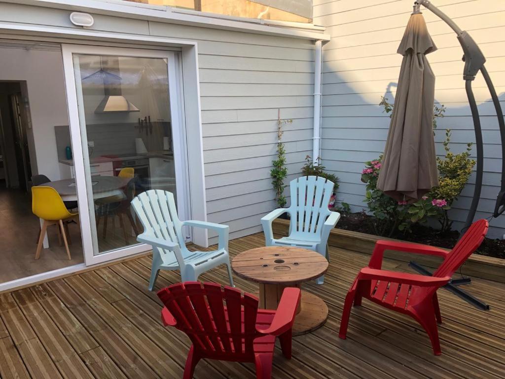 a group of chairs and a table on a porch at La maison du bonheur proche plage composée de 2 appartement et d'une belle terrasse in Étaples