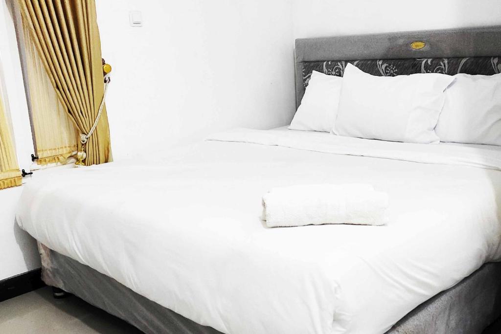 Postel nebo postele na pokoji v ubytování Pertiwi Homestay Near Museum Angkut Batu Mitra RedDoorz