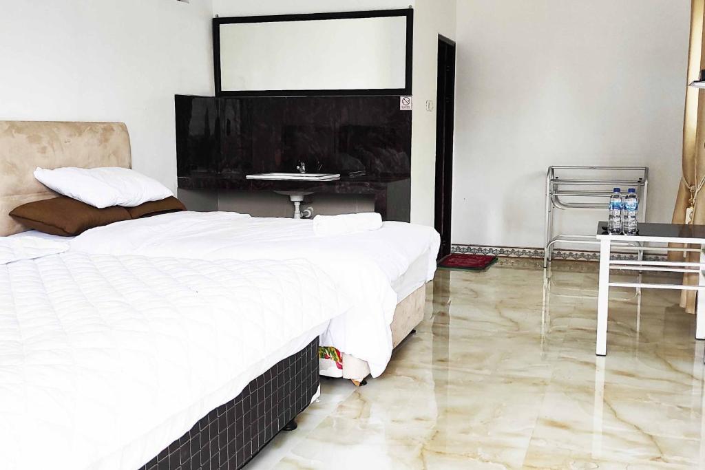 Postel nebo postele na pokoji v ubytování Pertiwi Homestay Near Museum Angkut Batu Mitra RedDoorz