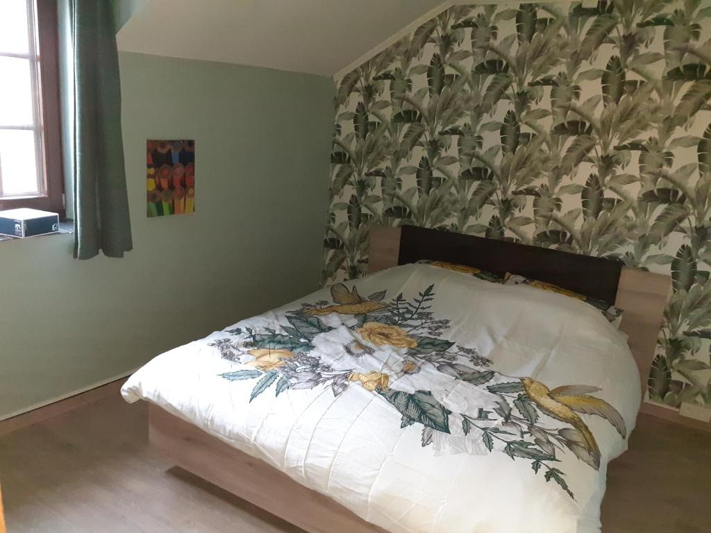 1 dormitorio con 1 cama y papel pintado con motivos florales en Gîte al fontaine, en La-Roche-en-Ardenne