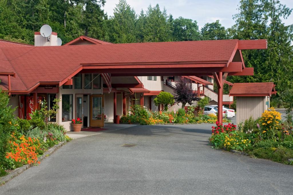 a building with a red roof and some flowers at Sequim Bay Lodge in Sequim