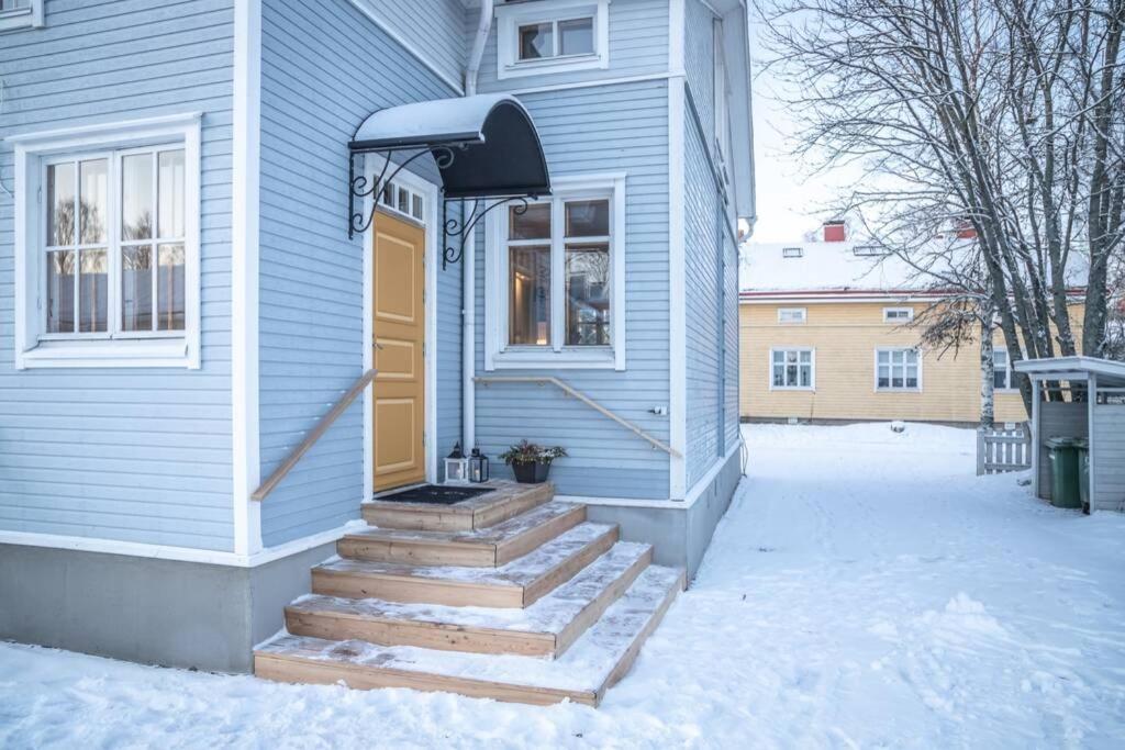 a blue house with stairs leading to a door at Cozy 1 Br Apt and Free parking by the Railway station in Oulu