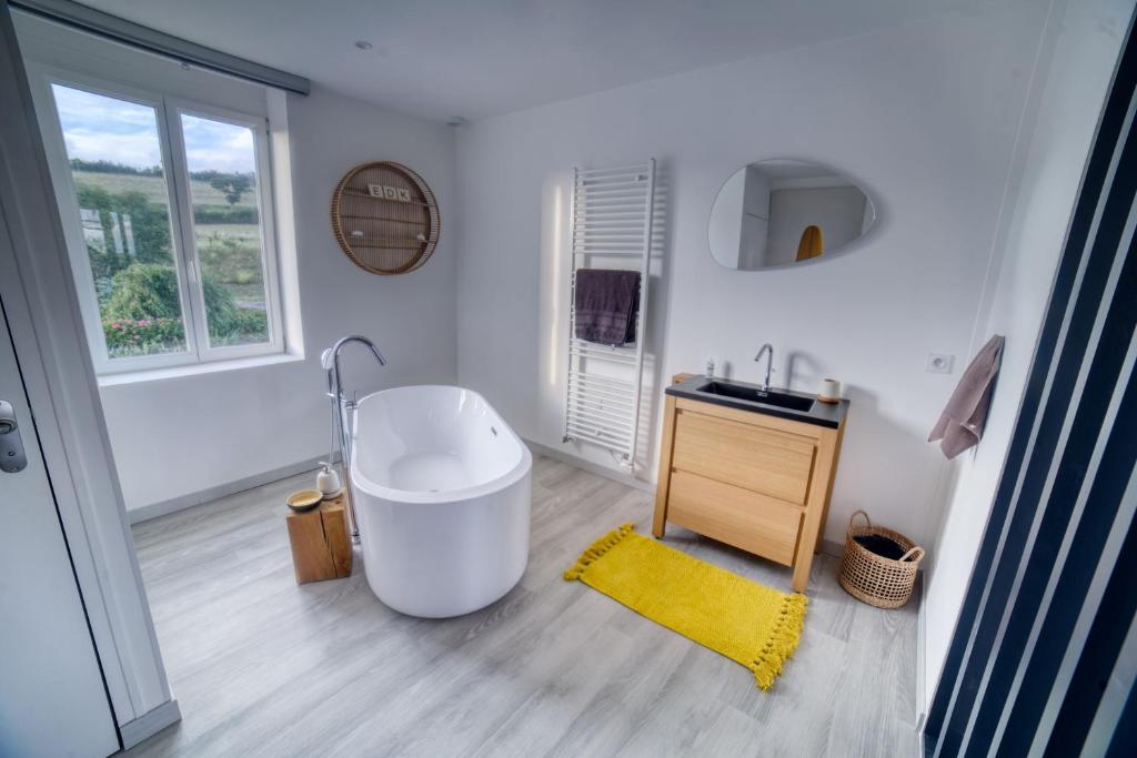 uma casa de banho com uma banheira grande e um lavatório em Etoile du Kap em Barneville-Carteret