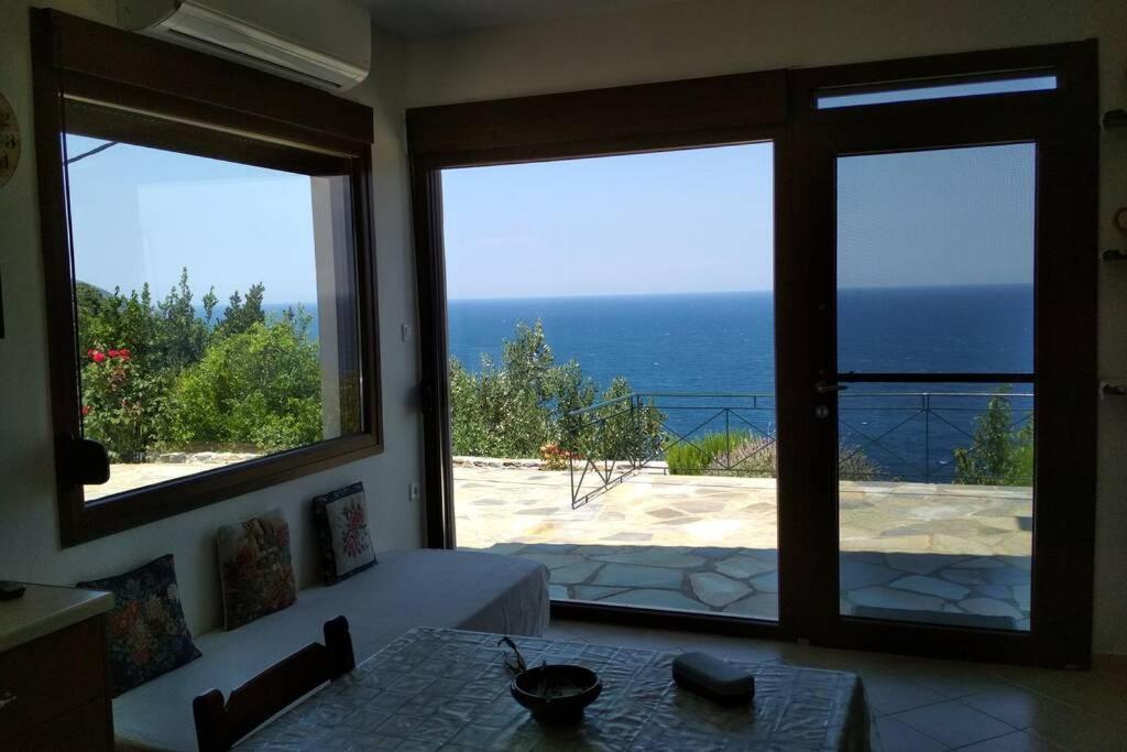 ein Esszimmer mit Meerblick durch Fenster in der Unterkunft Balcony to the Aegean Sea - Pelion, Lampinou in Pilion