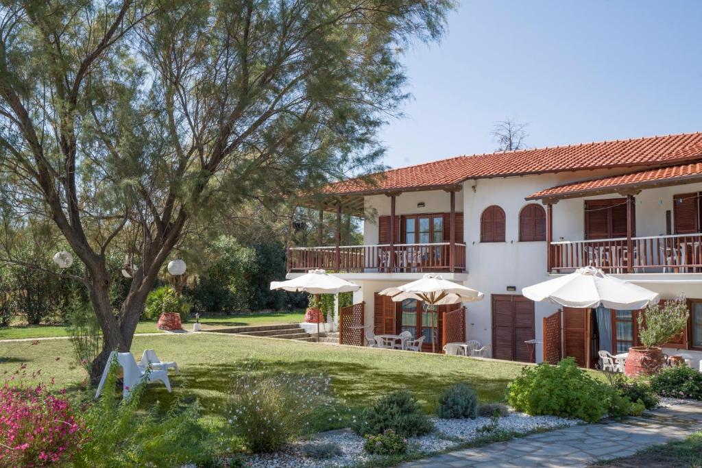una casa con un patio con sombrillas en Villa Papapostolou, en Ierissos