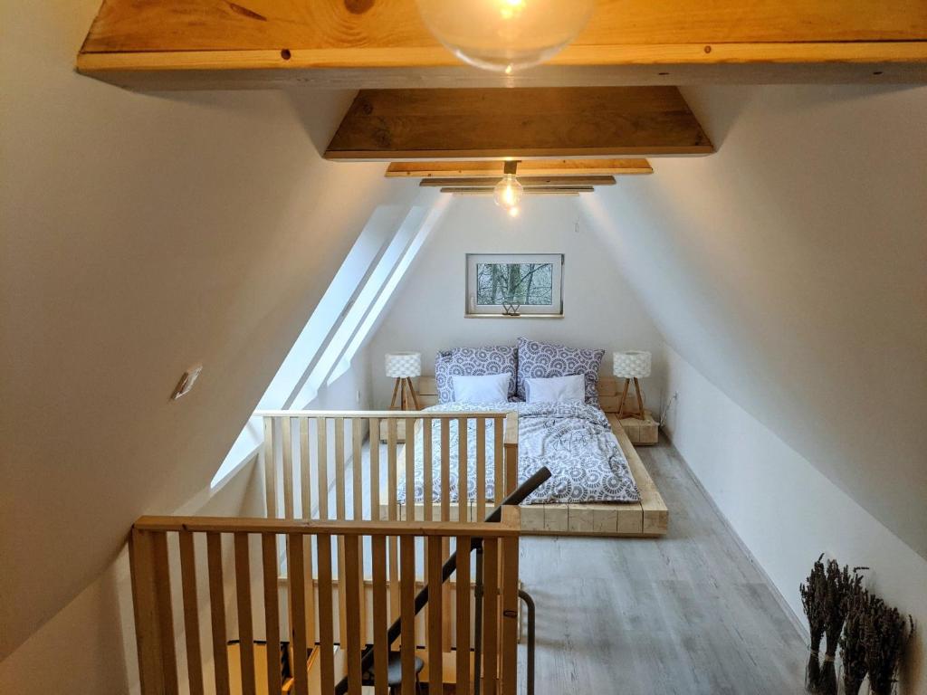 a attic bedroom with a bed and a staircase at A Ház in Kismaros