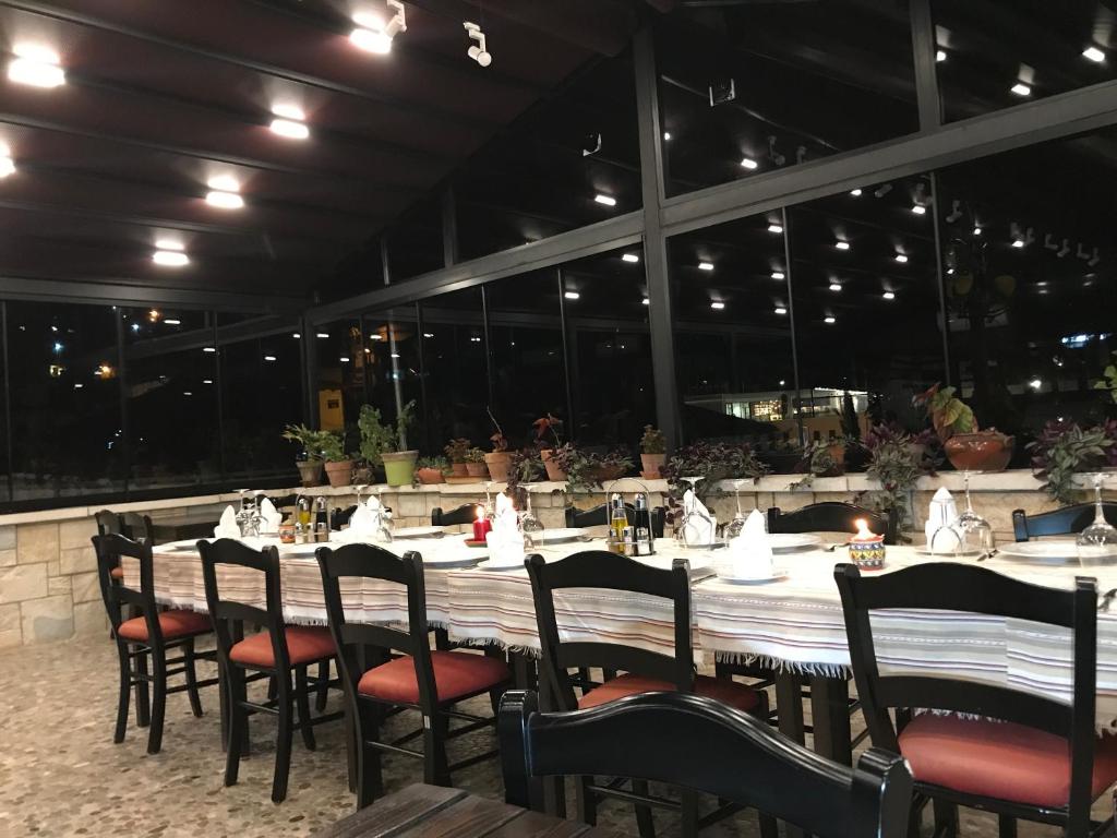 un lungo tavolo con sedie in un ristorante di Hotel Mangalemi a Berat