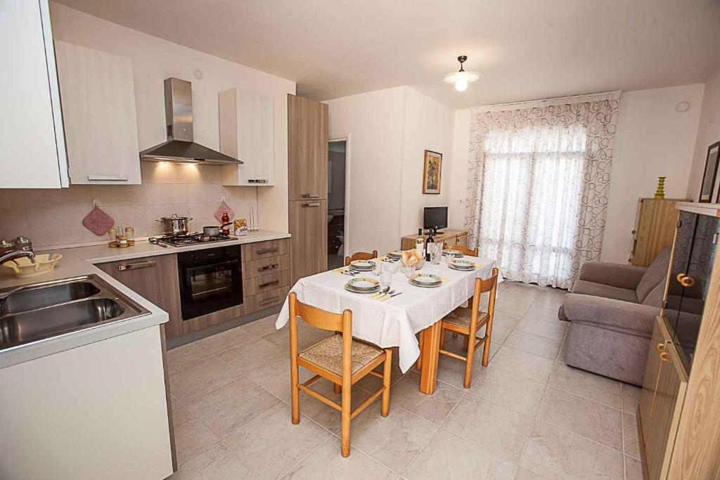 - une cuisine et une salle à manger avec une table et des chaises dans l'établissement Apartments in Rosolina Mare 25088, à Rosolina Mare