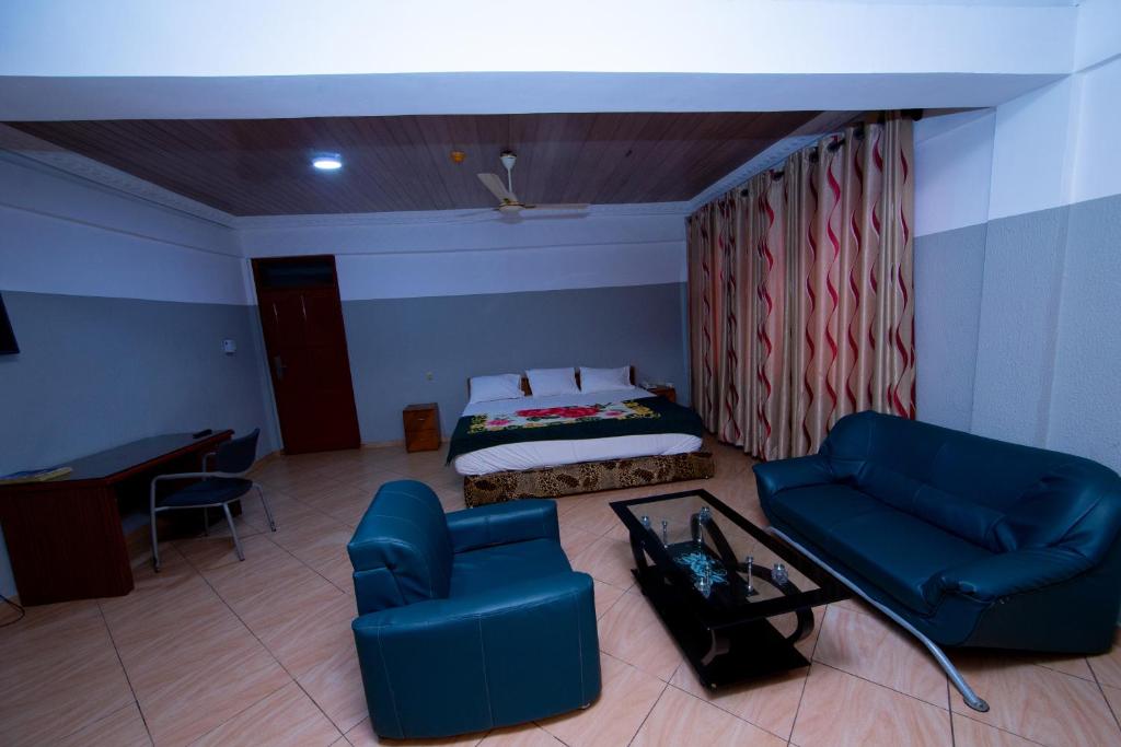SpintexにあるPemicsa Hotel Accraのベッド、ソファ、テーブルが備わる客室です。