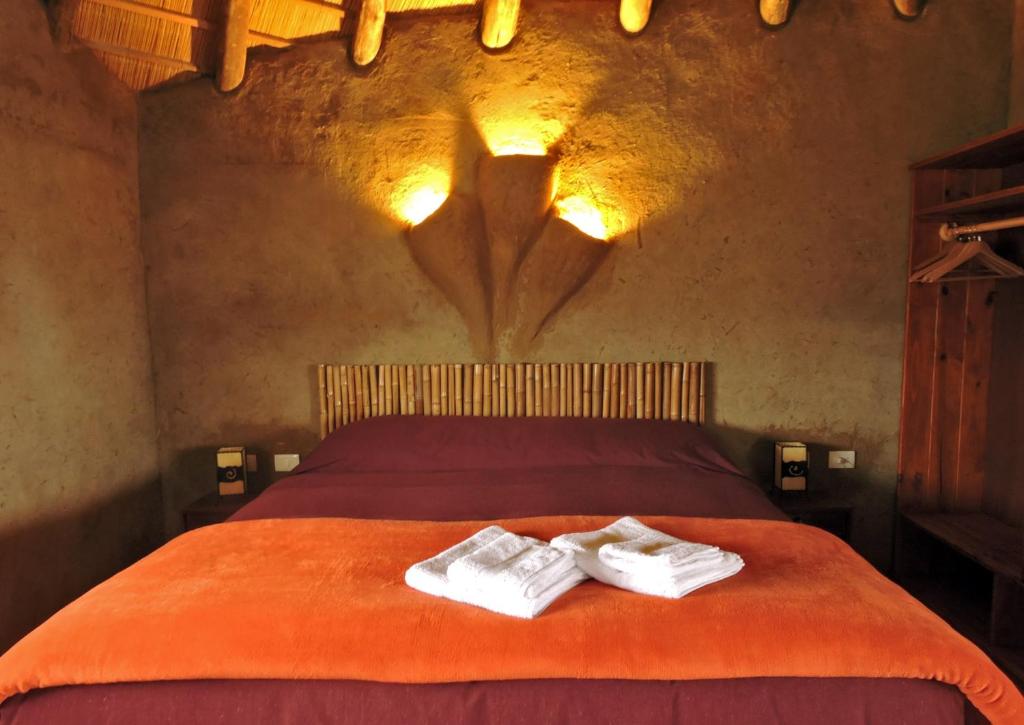 1 dormitorio con 1 cama con 2 toallas en Los Chajá Ecolodge, en Barra de Valizas