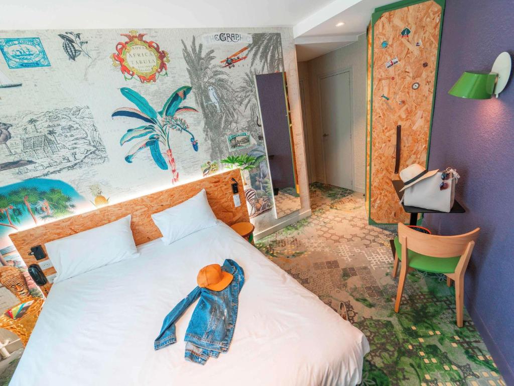 a bedroom with a bed with a stuffed animal on it at ibis Styles Paris Boulogne Marcel Sembat in Boulogne-Billancourt