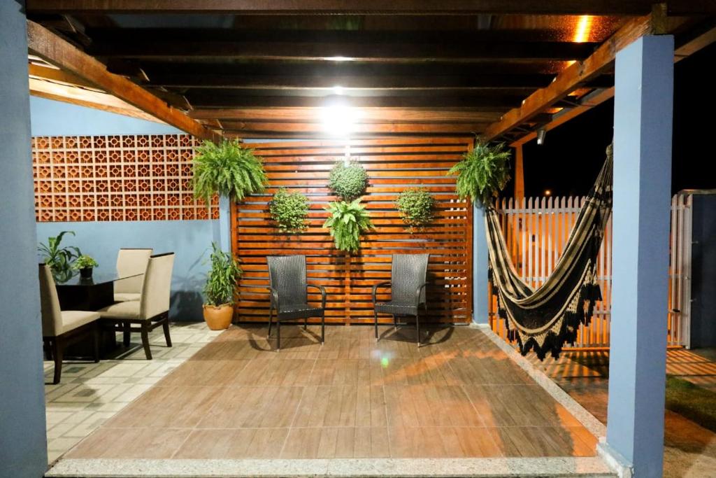 um quarto com cadeiras e plantas numa parede em BETEL Hospedagem em Penha