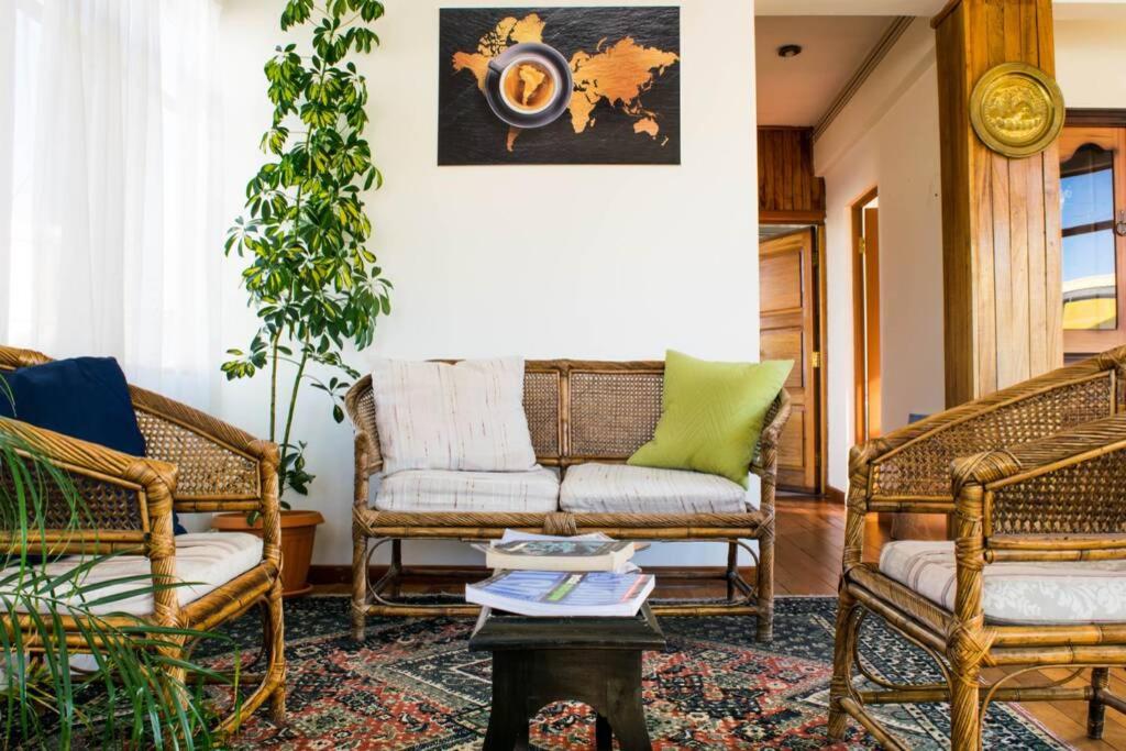 uma sala de estar com cadeiras de vime e um sofá em Bright & Comfy Guest House in La Paz em La Paz