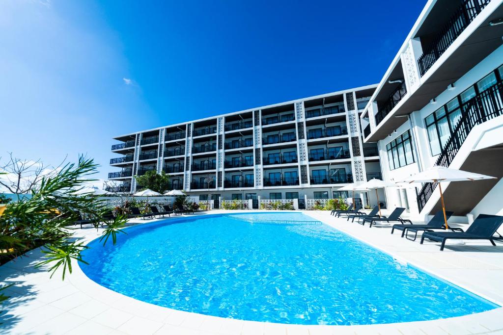 a swimming pool in front of a building at Hotel Torifito Miyakojima Resort in Miyako-jima