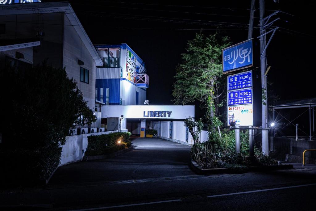 a building with a lit up sign at night at Hotel Liberty Matsuyama (Adult Only) in Matsuyama