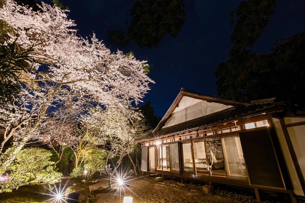 una casa con luces delante de un árbol por la noche en Miidera Onjo-ji en Otsu