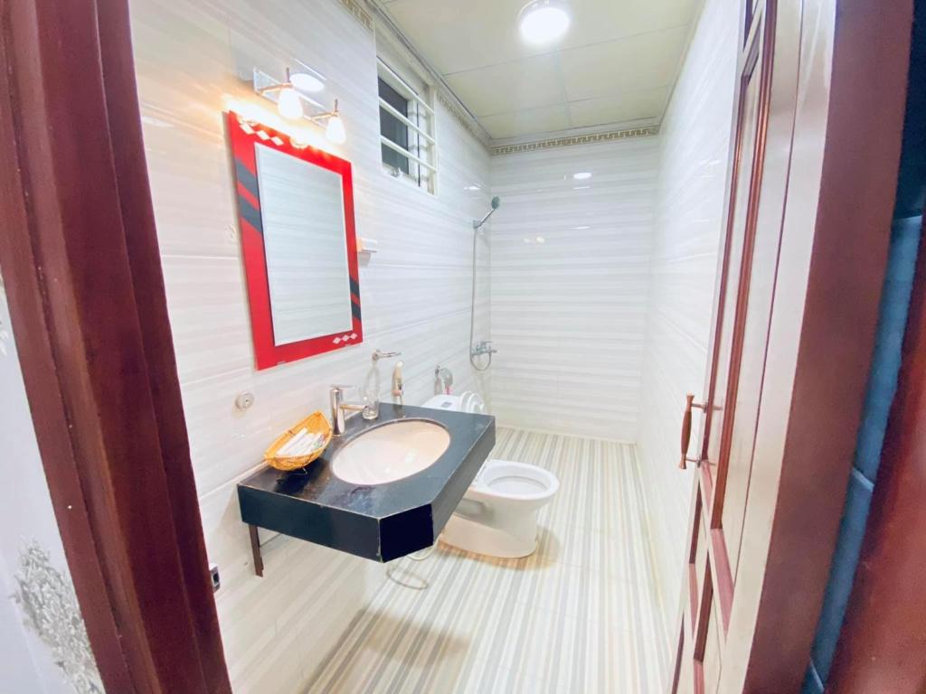 y baño con lavabo y aseo. en Hoàng Anh hotel, en Ðưc Trọng
