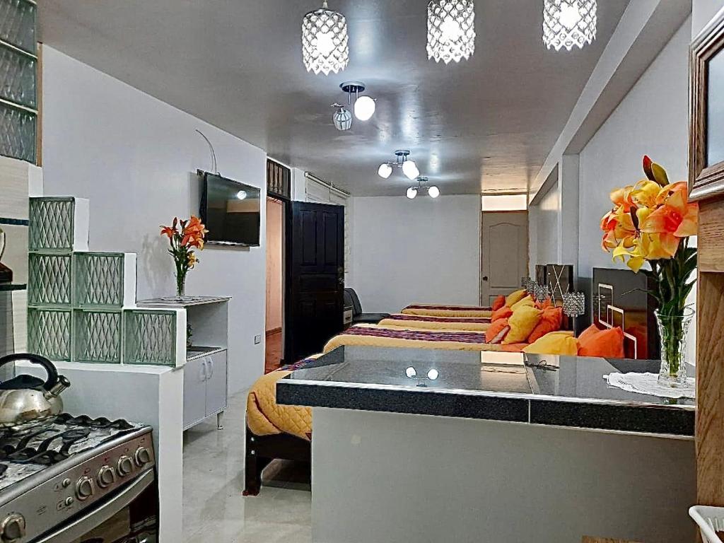 a room with a bed and a kitchen with a stove at Cusco Magico 6 - Mini Departamento Santa Ursula in Cusco