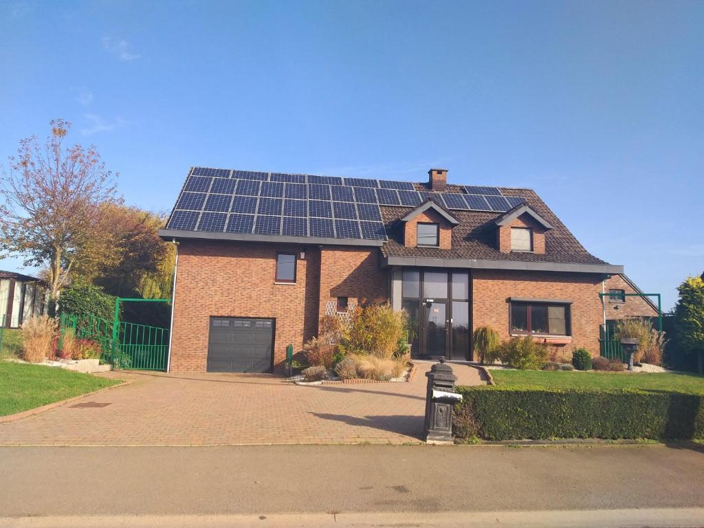 a house with solar panels on the roof at Maison de vacances située entre Liège, Tongres et Visé 