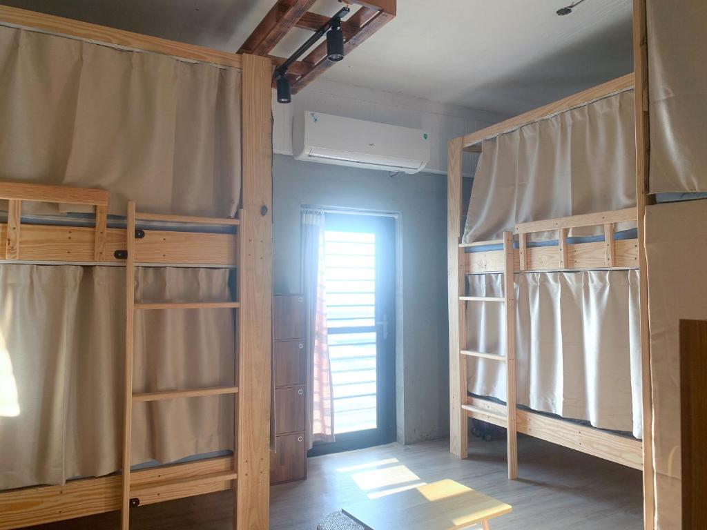That day Hostel 那天旅宿 في Lanyu: غرفة بسريرين بطابقين ونافذة