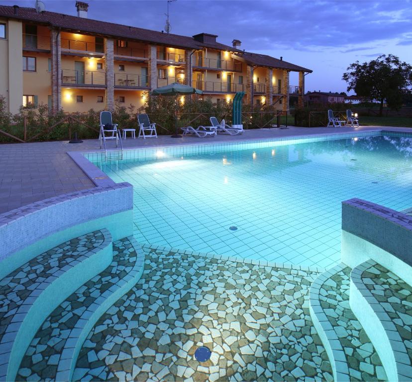 a swimming pool in front of a building at Il Milione Country Hotel in Palazzolo dello Stella