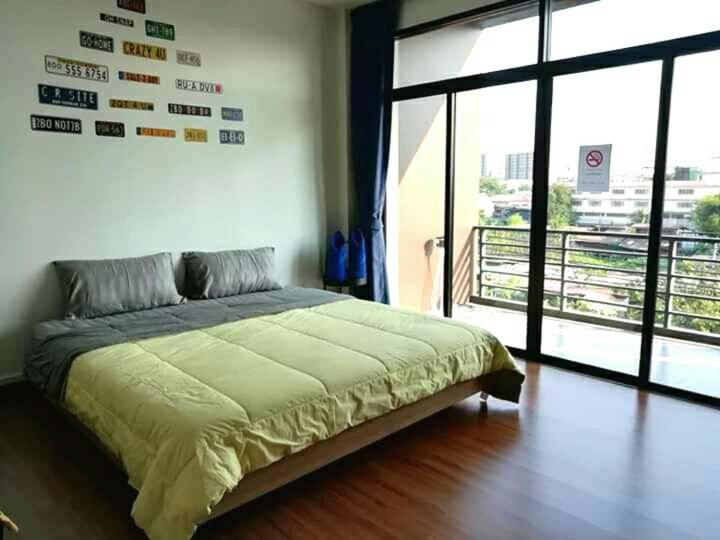バンコクにあるSleepy and Homey Don Mueang Airport Hostelのベッドルーム1室(ベッド1台、大きな窓付)